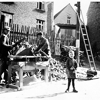 Bild0004 Holzschnittplatz Eltviller Strasse. Vor dem Haus Otto Gräßer / Hohmann. In der Mitte die Hofeinfahrt Karl Wink, re. die Scheune Bodenheimer. An der Säge August...